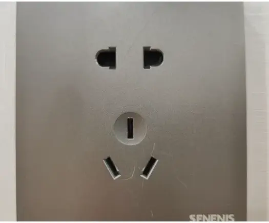 A real Chinese wall socket (Type A + I combo) — two flat slots on top, a round earth pin, and two angled flat slots below